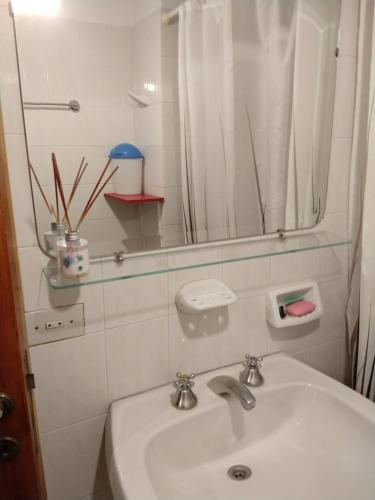 y baño con lavabo blanco y espejo. en Capricornio en Salta