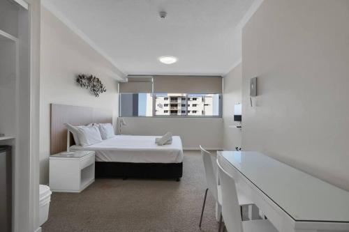 a white bedroom with a bed and a window at Excellent Location - Modern Hotel Room in Mackay in Mackay