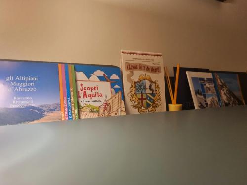 a group of books sitting on top of a shelf at G.S House in LʼAquila