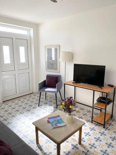 a living room with a television and a table at Casa Azul em Alcantarilha - Algarve in Alcantarilha