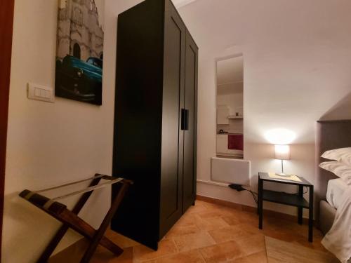 a bedroom with a black cabinet next to a bed at G.S House in LʼAquila