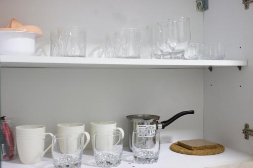 a shelf with glasses and a blender on it at Town Space Apartment Niš in Niš