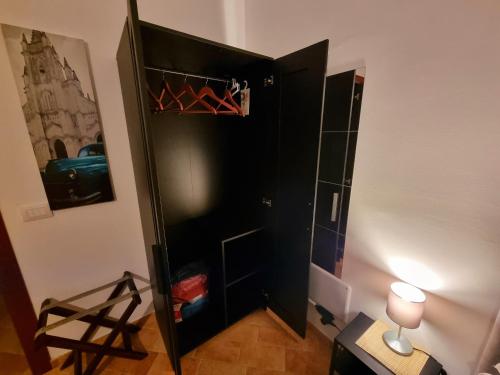 a black closet in a room with a lamp at G.S House in LʼAquila