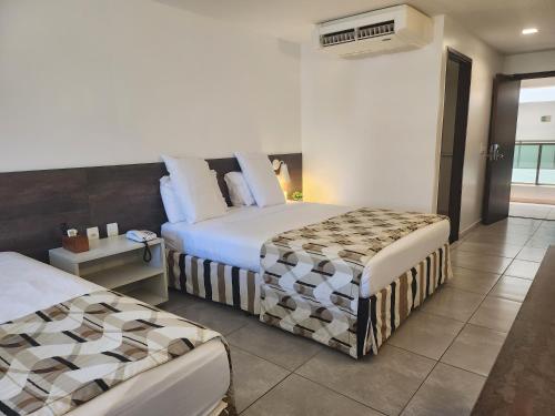 マセイオにあるRitz Suites Maceió Flat particular Temporadaのベッド2台とバルコニーが備わるホテルルームです。