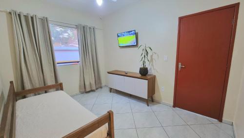 a room with a bed and a desk and a window at Residencial Las Rocas I in Florianópolis