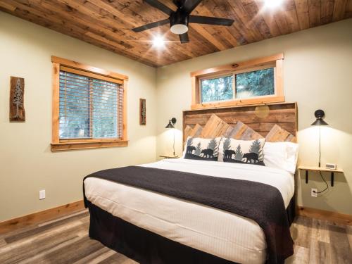 ein Schlafzimmer mit einem großen Bett und zwei Fenstern in der Unterkunft Cottonwood Cabin in Glacier