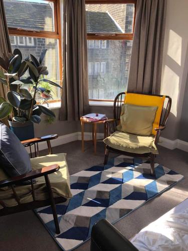 a living room with chairs and a rug at The Cross Inn in Hebden Bridge