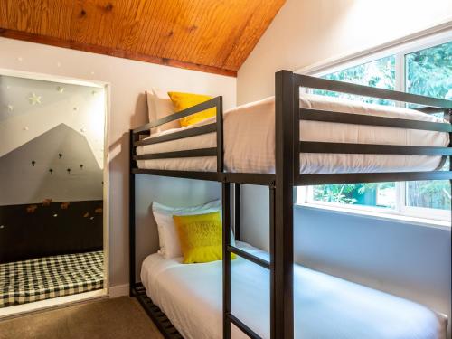 Zimmer mit Etagenbett, 2 Etagenbetten und einem Spiegel in der Unterkunft Kulshan Cabin in Glacier