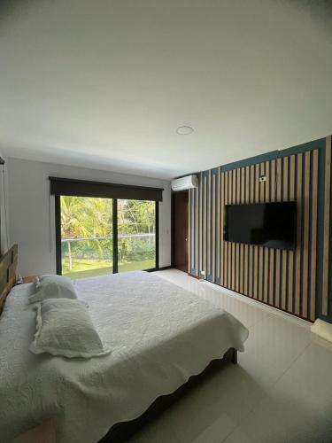 a bedroom with a large bed and a flat screen tv at Cabaña en santafe de Antioquia in Santa Fe de Antioquia
