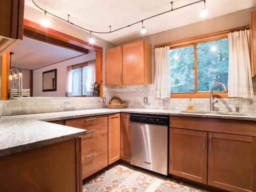 a kitchen with wooden cabinets and a stainless steel dishwasher at Pendleton Pines Lodge in Glacier