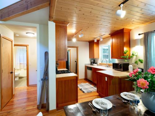 a kitchen with wooden cabinets and a table with flowers at Heliotrope Haus in Glacier