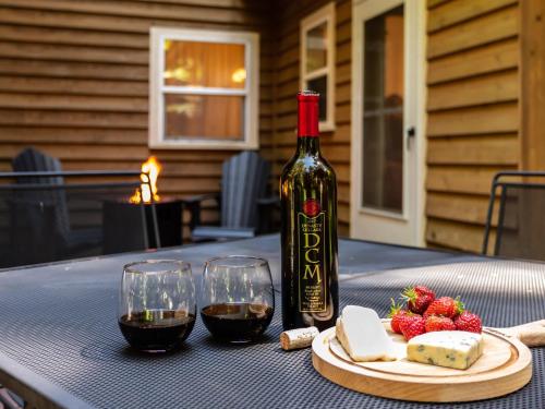 a bottle of wine and a plate of cheese and wine glasses at Heliotrope Haus in Glacier