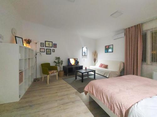 a bedroom with a bed and a living room at Town Space Apartment Niš in Niš