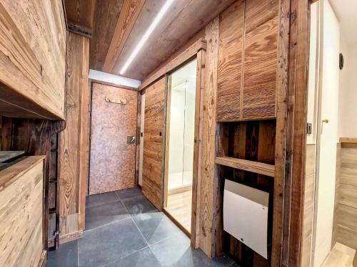 - un couloir avec des boiseries et un dressing dans l'établissement Studio rénové au centre de Val d'Isère - Balcon, proche pistes, cuisine équipée - FR-1-518-137, à Val dʼIsère