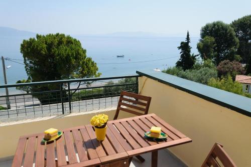 a wooden table and chairs on a balcony at Beautiful seaside studio with amazing view in Athens
