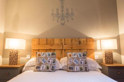 um quarto com uma cama com 2 candeeiros e um lustre em The King's Head em Winchester