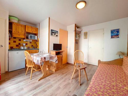 une cuisine et une salle à manger avec une table et des chaises dans l'établissement Studio fonctionnel avec balcon, proche pistes, WiFi inclus, quartier calme des Fontanettes - FR-1-344-1068, aux Menuires