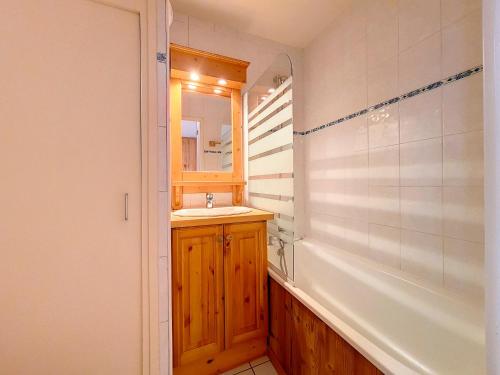 une salle de bain avec un lavabo et un miroir dans l'établissement Studio fonctionnel avec balcon, proche pistes, WiFi inclus, quartier calme des Fontanettes - FR-1-344-1068, aux Menuires