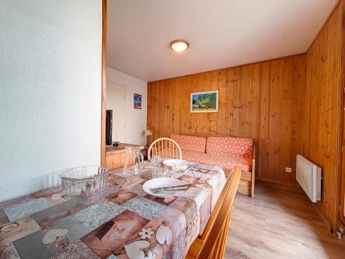 une salle à manger avec une table et un canapé dans l'établissement Studio fonctionnel avec balcon, proche pistes, WiFi inclus, quartier calme des Fontanettes - FR-1-344-1068, aux Menuires