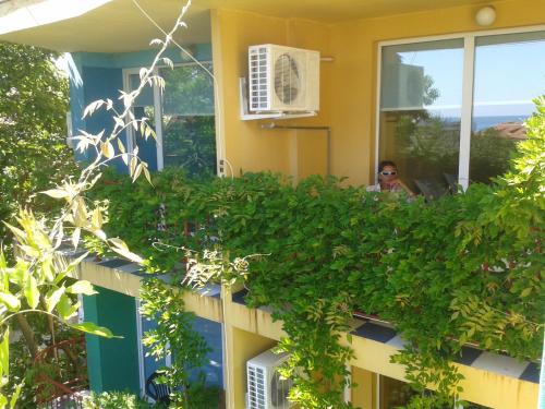 a woman sitting on a balcony of a house at The Colourful Mansion Hotel in Ahtopol