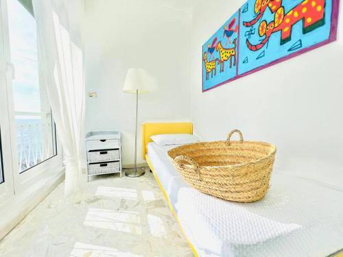 een mand op een bed in een kamer bij Suite Casa del Sole 16 - Fronte Mare in Sanremo