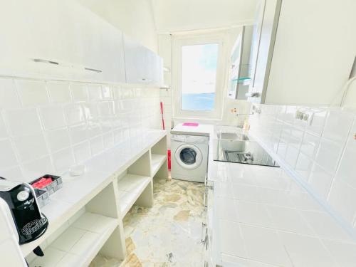 een witte wasruimte met een wasmachine bij Suite Casa del Sole 16 - Fronte Mare in Sanremo