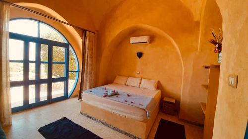 ein Schlafzimmer mit einem Bett in einem Zimmer mit einem Fenster in der Unterkunft Lemon tree villa in Tunis