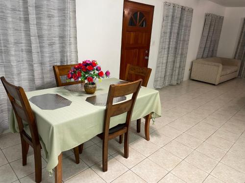 a table and chairs with a vase of flowers on it at Luxurious One and Two Bedroom Villa in Christiansted