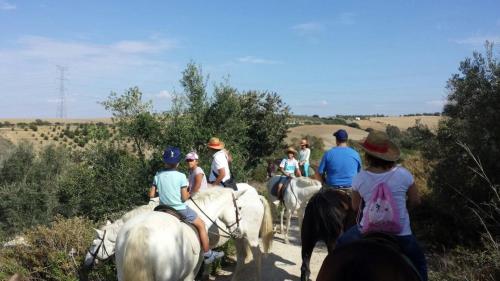 a group of people riding horses down a trail at Mesón de la Molinera in Arcos de la Frontera