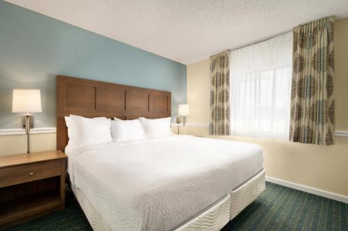 a bedroom with a large bed and a window at Days Inn & Suites by Wyndham Wildwood in Wildwood