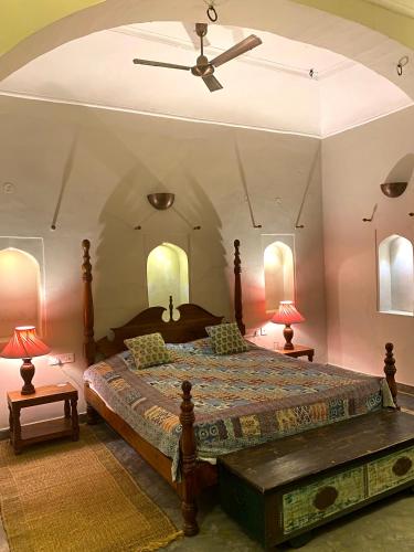a bedroom with a large bed and two lamps at Mandawa Kothi in Mandāwa