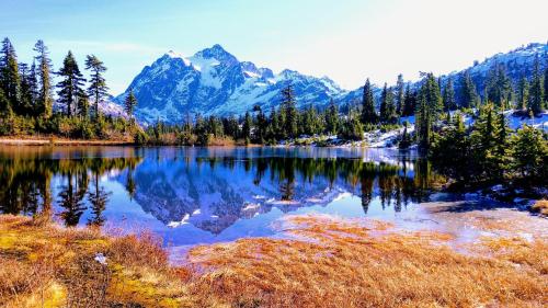 a mountain reflection in a lake with trees at Snowater Nook in Deming