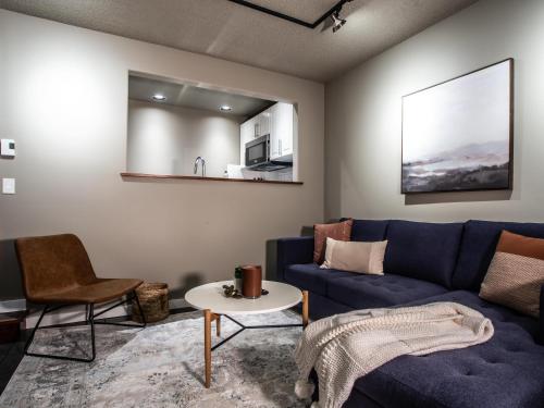 a living room with a blue couch and a table at Snowater Respite in Deming