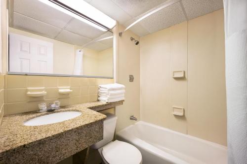 a bathroom with a sink and a toilet and a mirror at Sands Motel in Wildwood