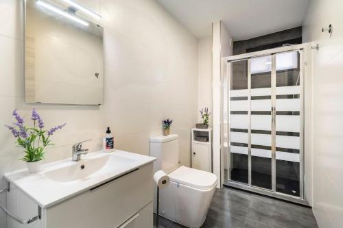 a white bathroom with a sink and a toilet at Apartamento Casa da barbeira in Cangas de Morrazo