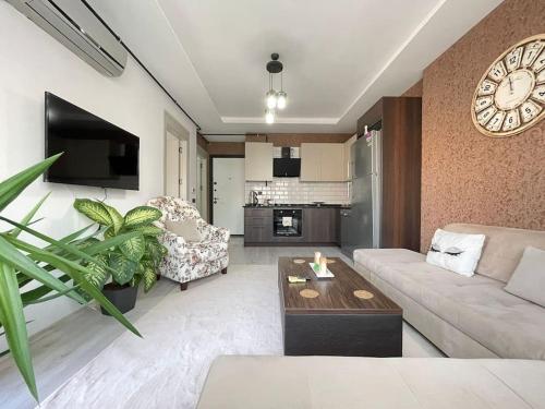 a living room with a couch and a clock on the wall at Merkezi konumda yeni dekore edilmiş şık daire in Mersin
