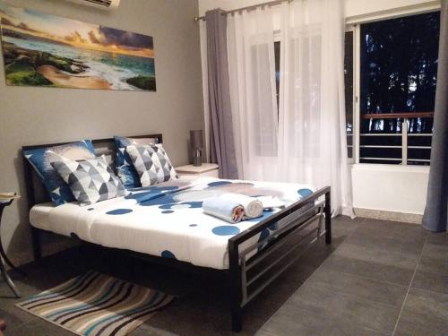 a bedroom with a large bed with a window at Beachfront Apartment(roadside- 30 meters to beach) in Flic-en-Flac