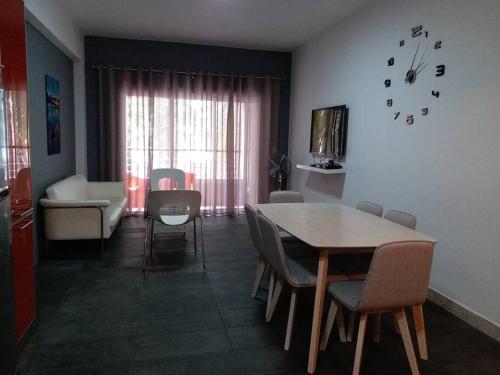 a living room with a table and chairs and a couch at Beachfront Apartment(roadside- 30 meters to beach) in Flic-en-Flac