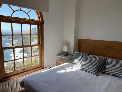 a bedroom with a bed and a large window at Linda casa con terraza y vista al mar in Viña del Mar