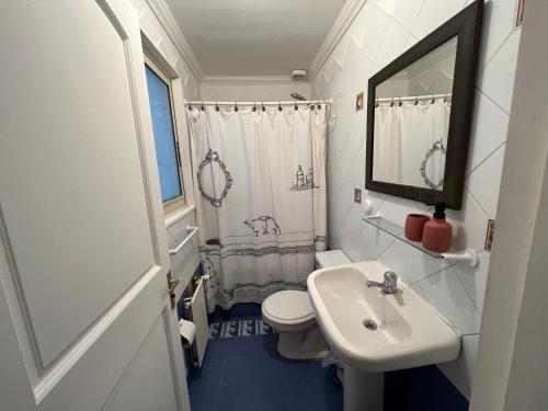 a bathroom with a sink and a toilet and a mirror at Linda casa con terraza y vista al mar in Viña del Mar