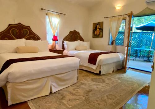 a bedroom with two beds and a balcony at The Emerald Iguana Inn in Ojai