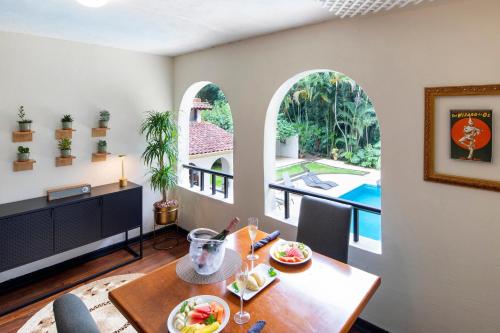 a dining room with a table and two arched windows at Villa San Ignacio in Alajuela City