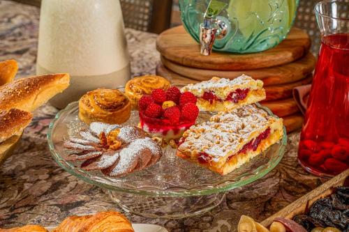 een glazen bord met gebak en fruit op een tafel bij Makmani Boutique Hotel in Tbilisi City