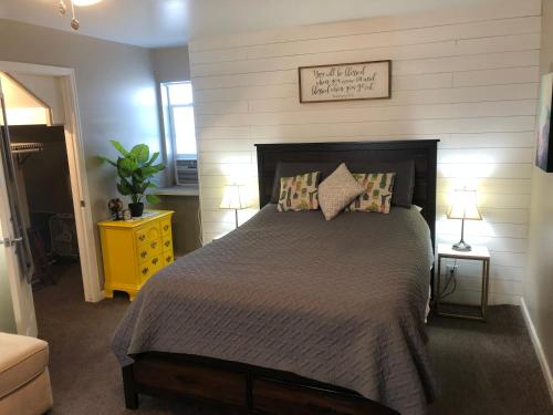 a bedroom with a large bed and a yellow nightstand at Cozy Studio in Grand Junction