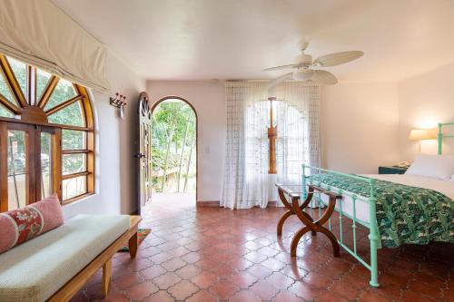 a bedroom with a bed and a couch and a window at Villa San Ignacio in Alajuela City