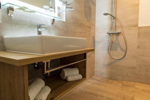 a bathroom with a sink and a shower at DAS GEORG Gästehaus in Epfendorf 