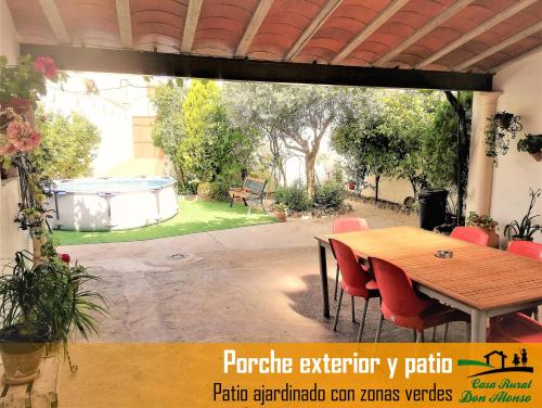 un patio con mesa y sillas y un jardín en Casa Rural Don Alonso, en Villalgordo del Júcar