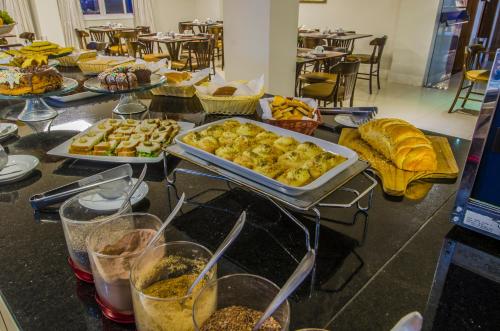 a table topped with trays of food on a table at Klein Ville São Leopoldo in São Leopoldo