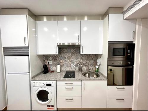 a white kitchen with a sink and a dishwasher at Maximilian Dreams in Madrid