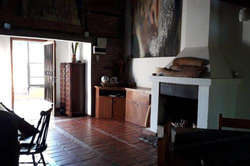 a living room with a fireplace and a table and chairs at El Teyu de Garupa in Garupá